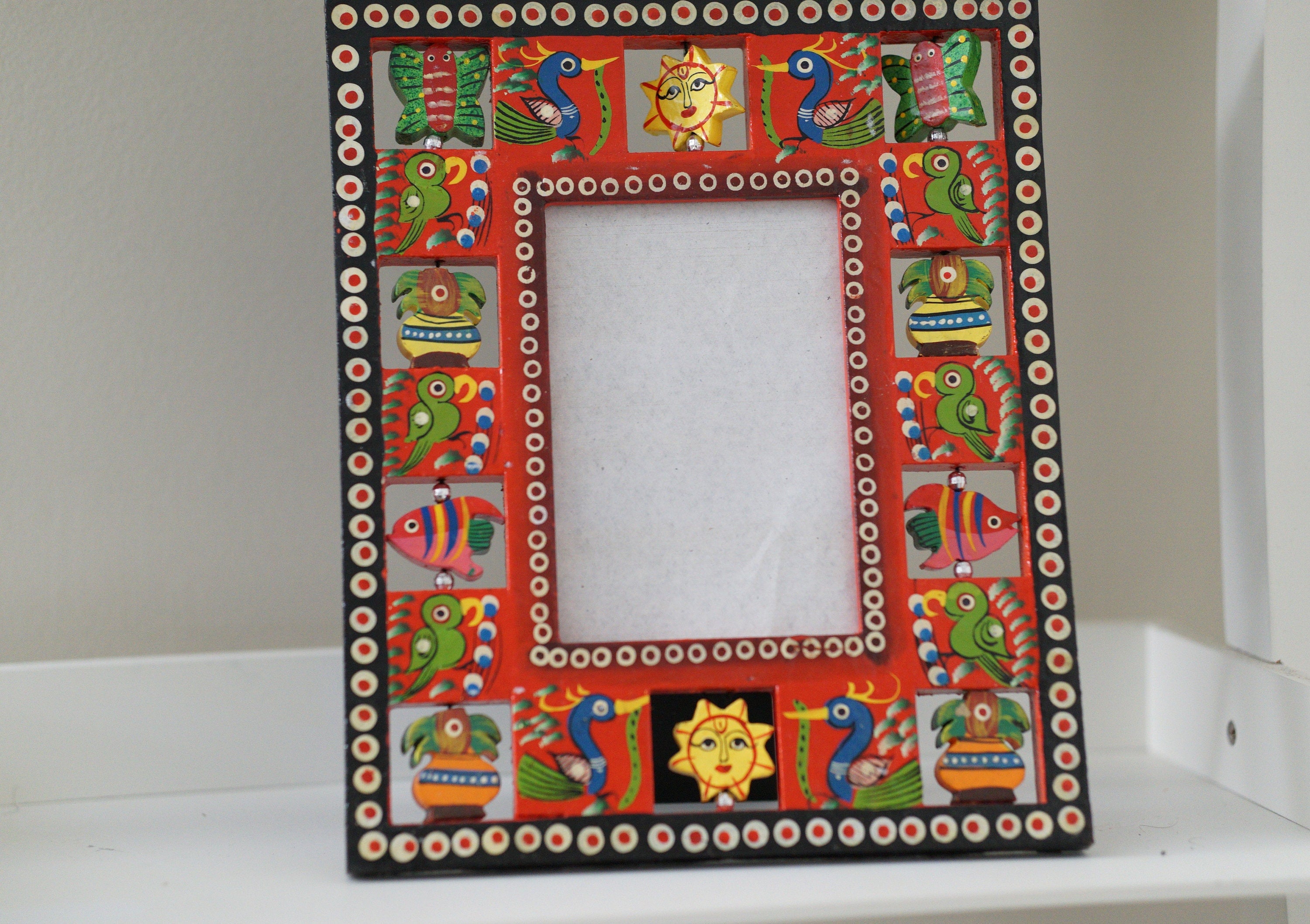 Colorful wooden photo frame with painted rotatable birds and figurines